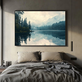 Misty mountain lake with pine forest and snowy peaks reflected in still water