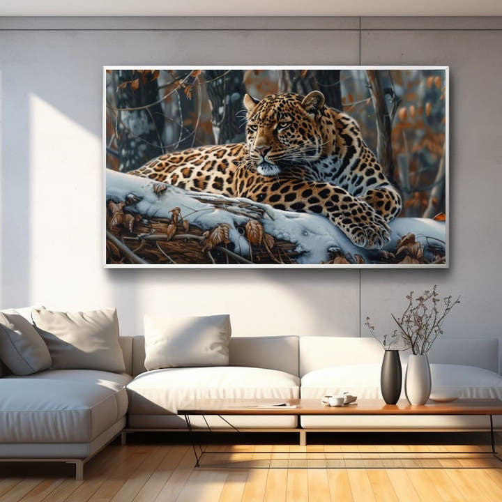 Leopard resting on a snow-dusted branch in autumn woodland