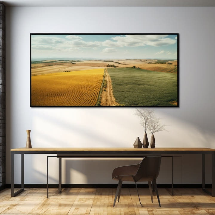 Aerial view of golden sunflower fields meeting green crops under a summer sky