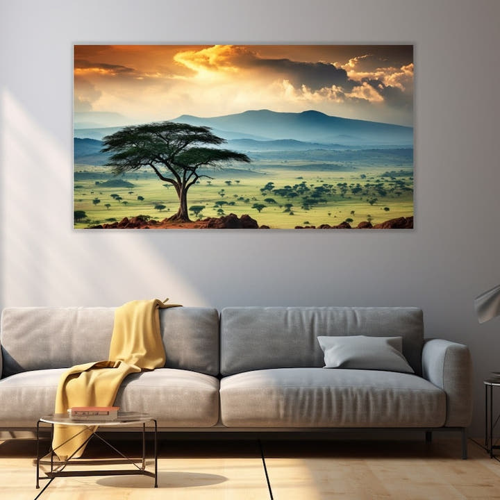 Savannah panorama with lone acacia at sunset and blue mountains