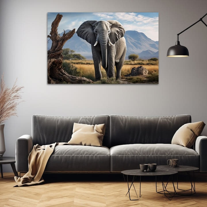 Grey African elephant crossing golden savannah beneath hazy mountains