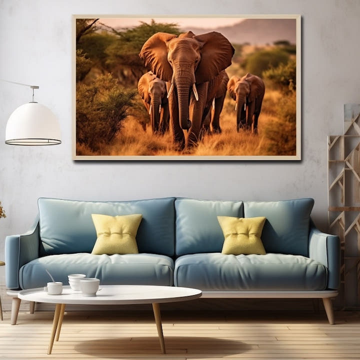 Herd of three African elephants walking through golden grassland