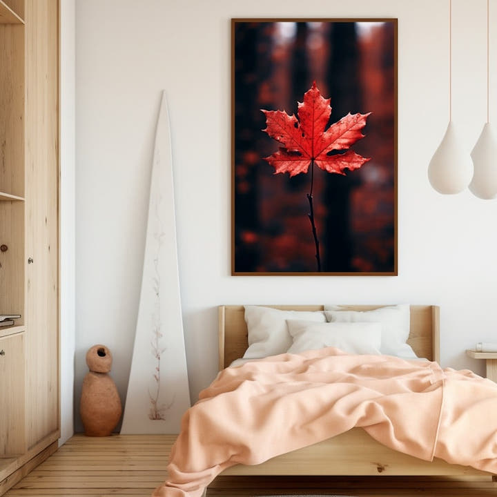 Single crimson maple leaf in focus against a blurred autumn forest