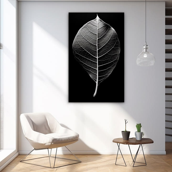 Black and white close-up of a single backlit leaf with silver veins on black