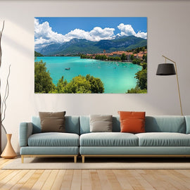 Painting of a turquoise alpine lake with a lakeside town and grey mountains