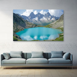 High alpine lake in vivid turquoise ringed by jagged snow-streaked granite peaks