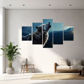 Grey wolf howling at dusk against blue mountain ridges