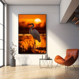 White egret silhouetted against a glowing orange sunset over water