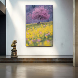Lone pink cherry blossom tree on a golden wildflower hillside