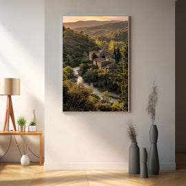 Golden-hour photograph of a stone hamlet and bell tower in a wooded valley