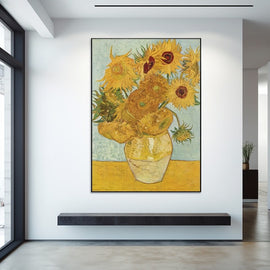 Van Gogh sunflowers in golden bloom in a cream vase against a turquoise wall